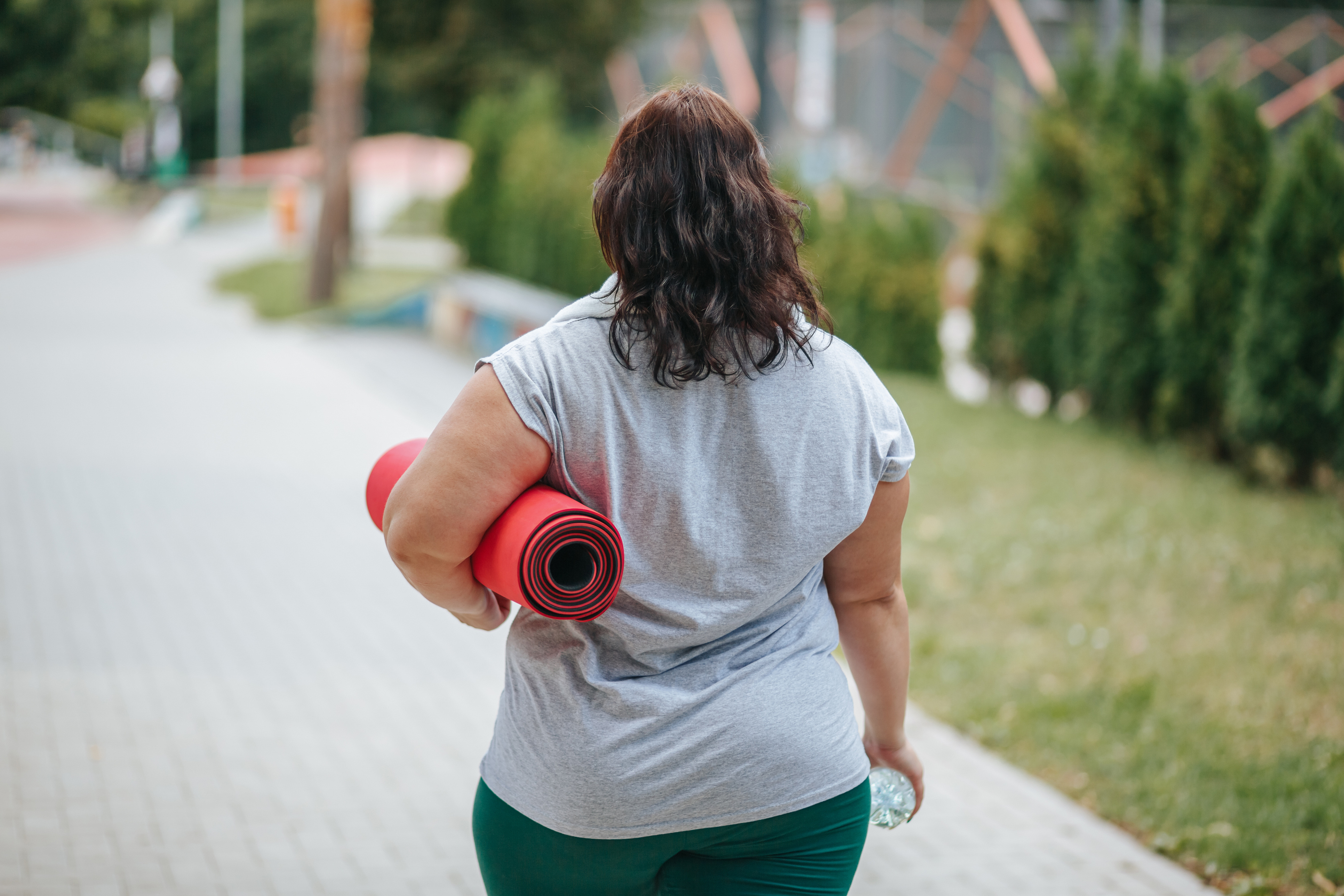 Overweight woman walking to yoga